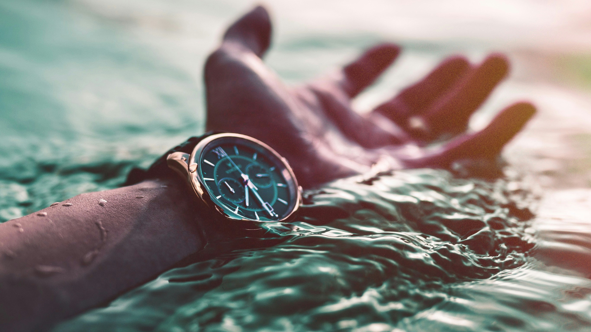 close shot of person's hand, the person is floating on a body of water