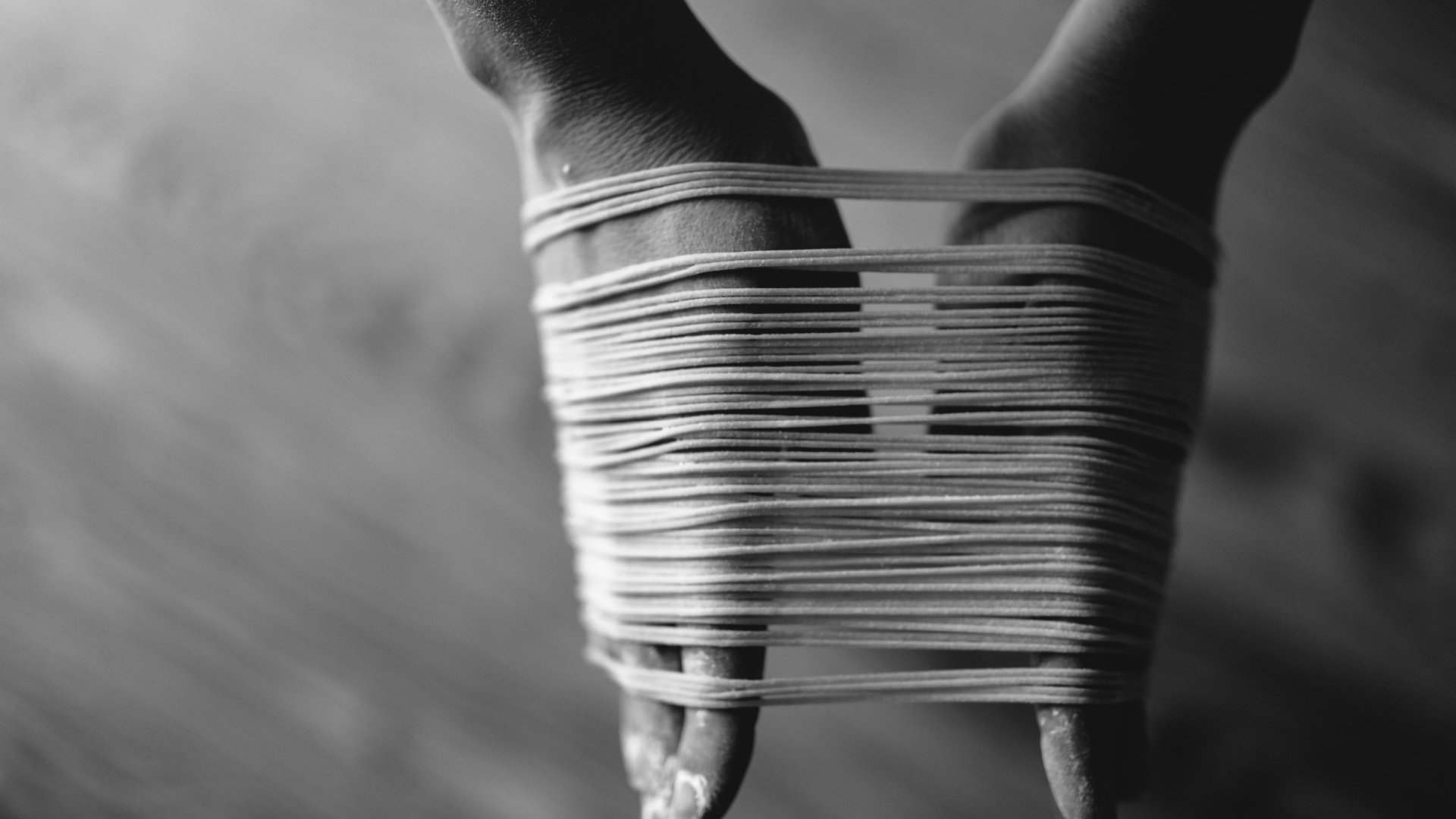 Close-up of bound hands creating tension