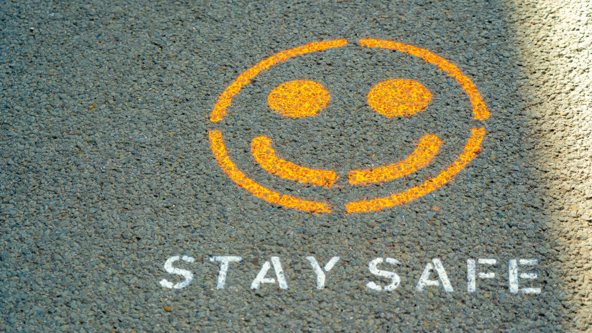 Painted sign on roadway that says Stay Safe