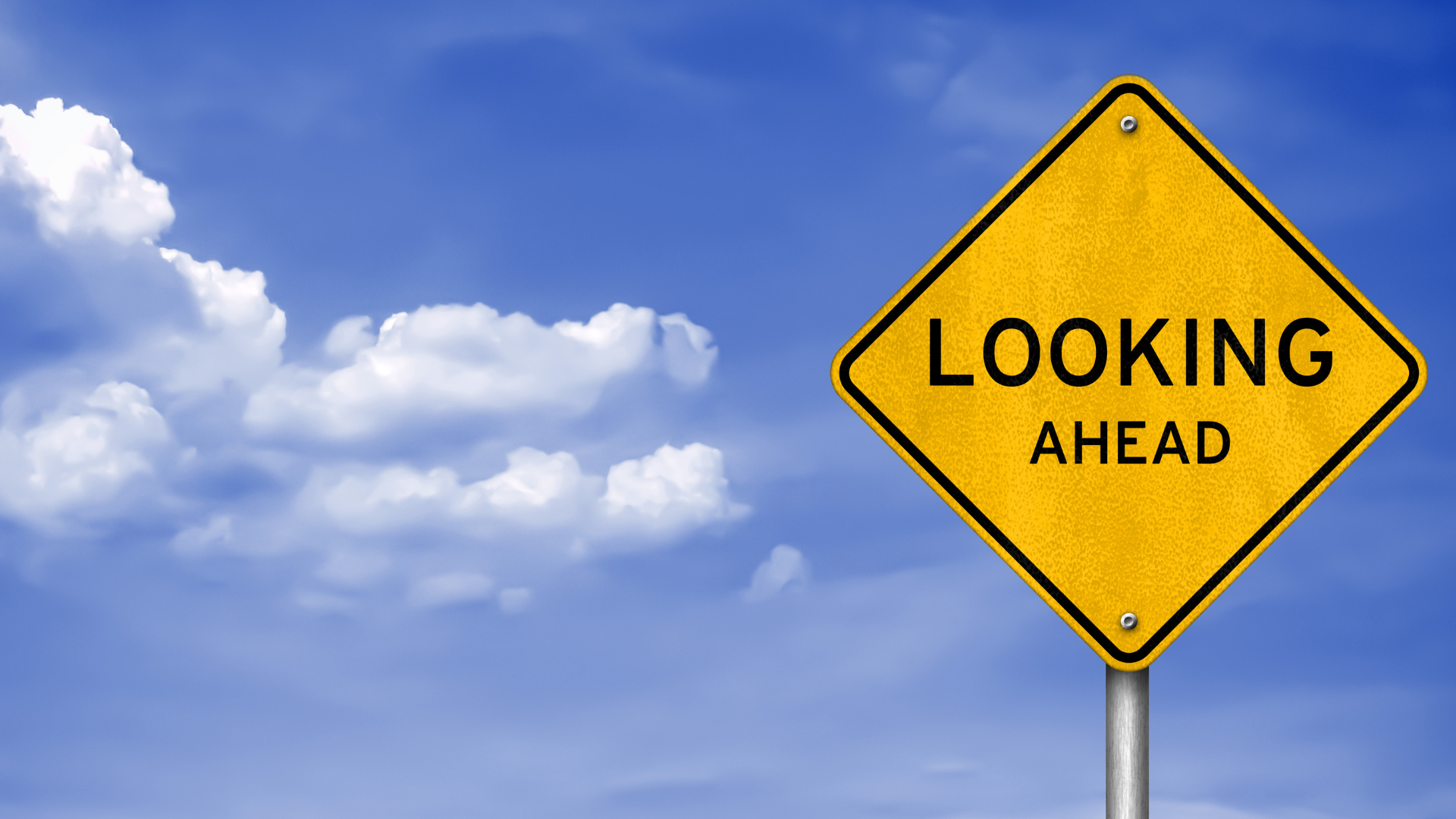 Photo of a yellow street sight with "Look Ahead" in black lettering on it