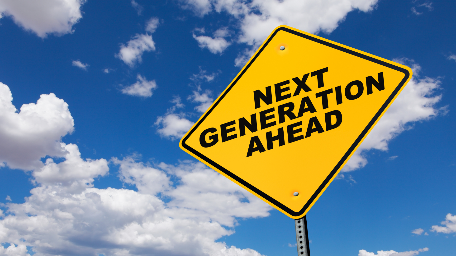A yellow diamond-shaped road sign with black lettering that reads "Next Generation Ahead"