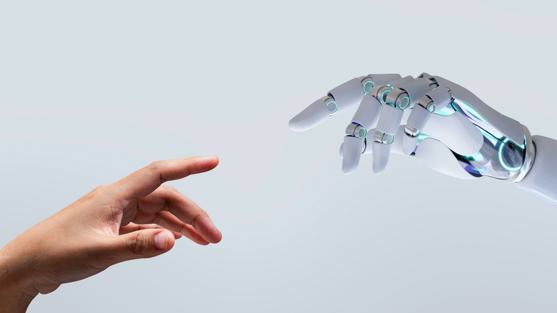 A photo of a human hand reaching up to a robot's hand