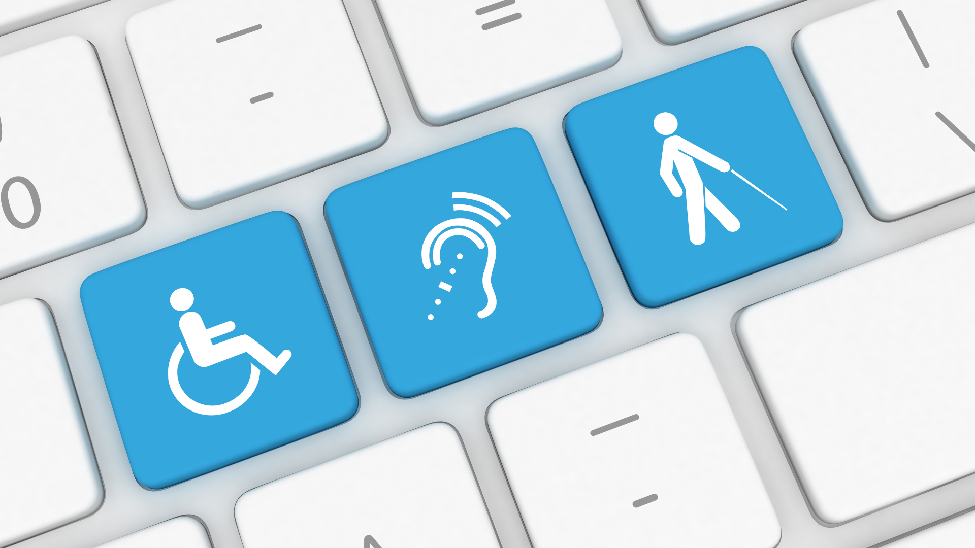 Close-up of a computer keyboard with three blue keys. The first key has a wheelchair icon, representing accessibility for those with mobility challenges. The second key features a hearing aid symbol, representing accessibility for individuals with hearing impairments. The third key has an icon of a person with a cane, representing accessibility for individuals with visual impairments.