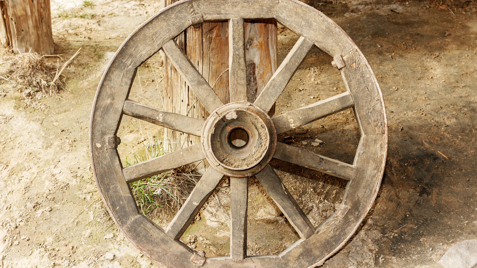 An old dirty wooden wagon wheel