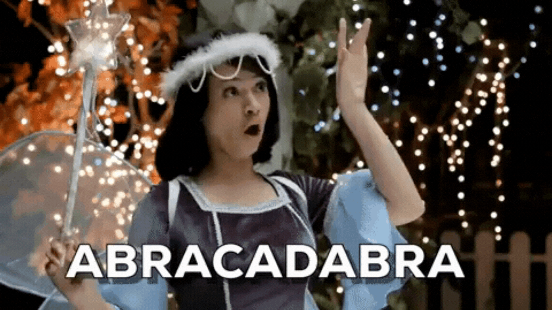 Animated GIF of a woman with brown hair wearing a fairy costume waiving a magic wand as the text 'Abracadabra' appears