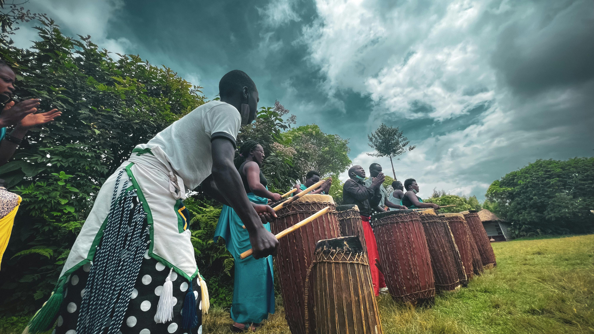 Low angle photo of an African tribe playing tall wooden drums