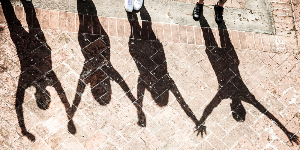 Shadows of community members with raised arms 