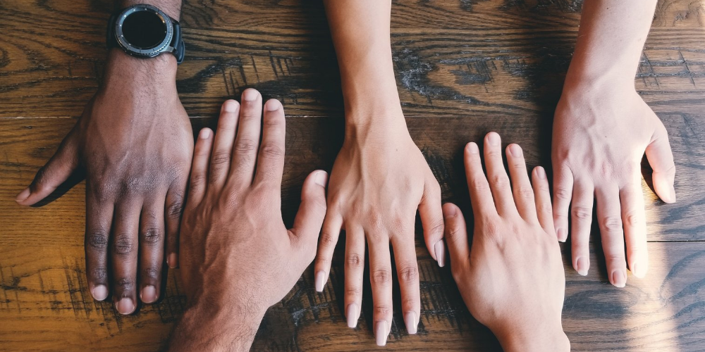 Diverse hands together on a table