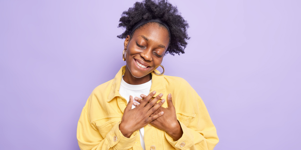 Pleased black woman makes thankful gesture