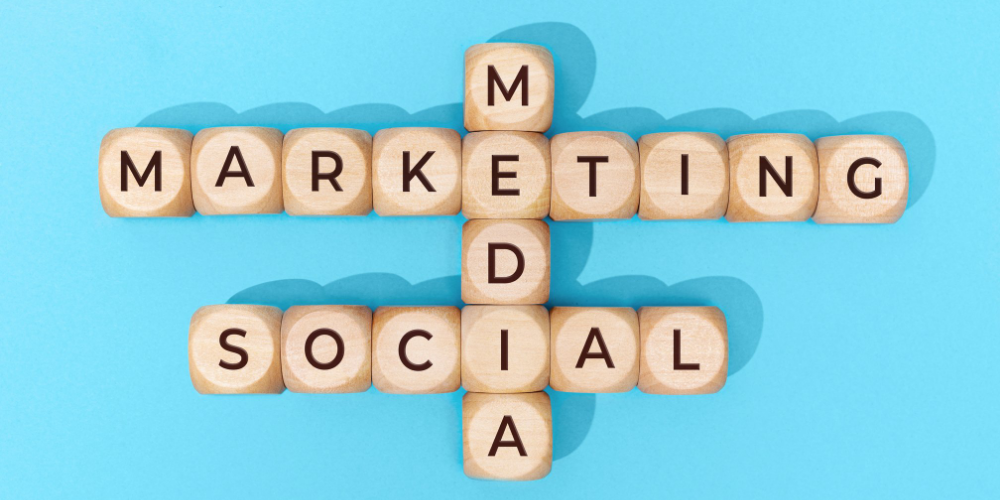 "Social Media Marketing" spelled on wooden letter blocks on blue background. 