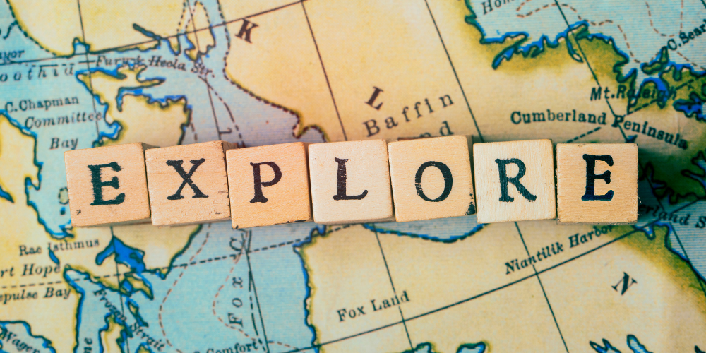The word EXPLORE in wooden blocks on vintage travel map