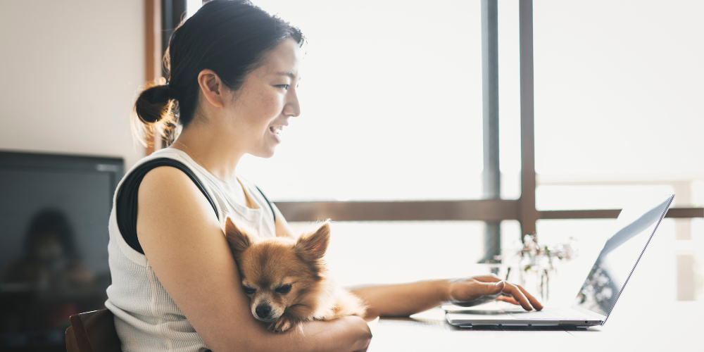 Woman with dog attending online rehearsal at home