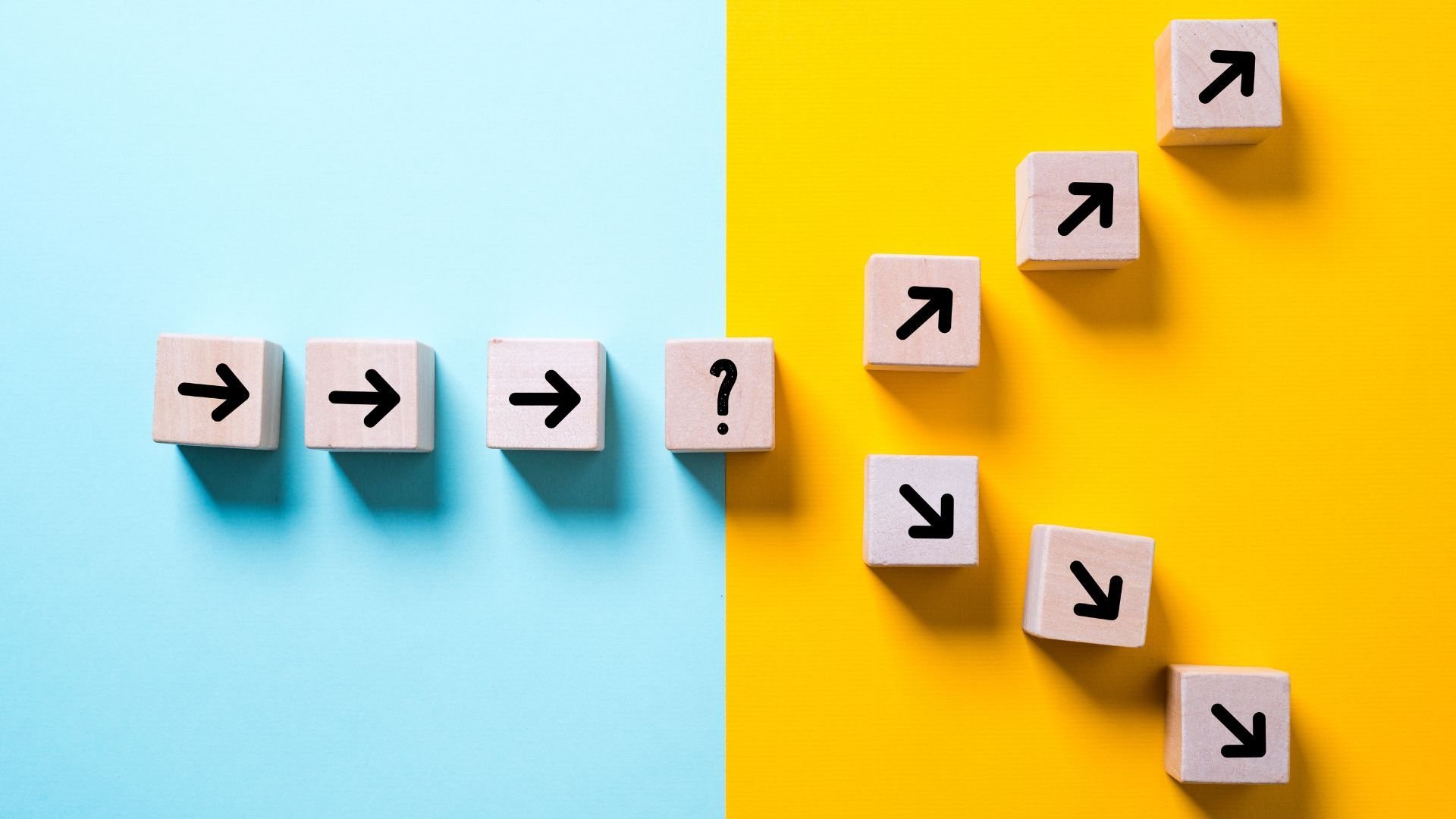 blue and orange background with wood blocks with arrows splitting into two different paths two choices 