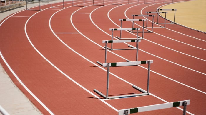 curving racetrack with hurdles in each lane