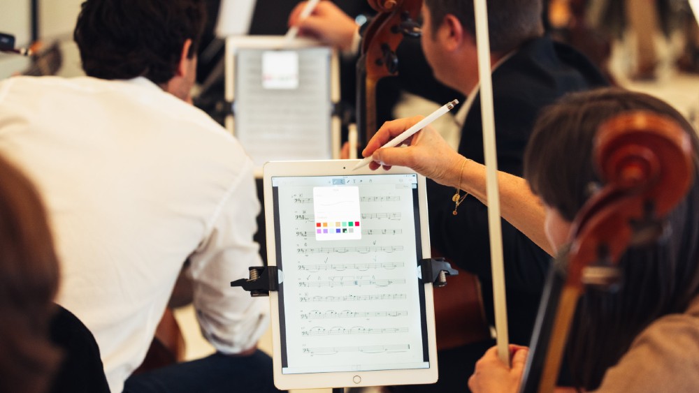 orchestra player making markings in digital score