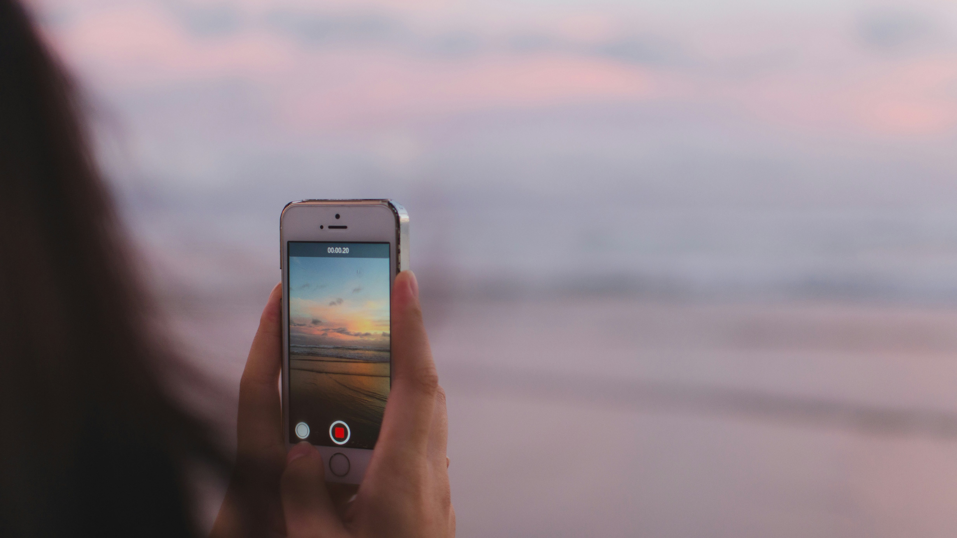 person taking a photo of of open sea and sunset