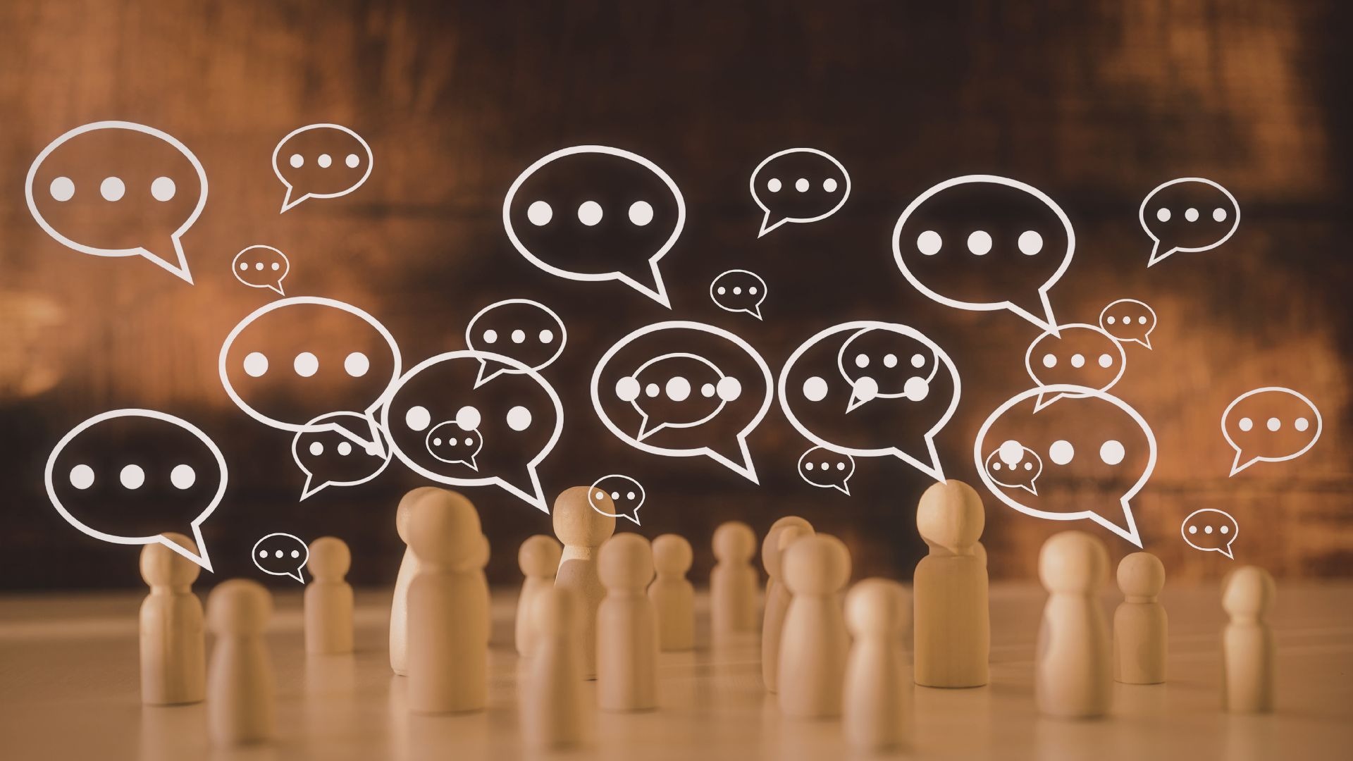 Illustration of small human figures surrounded by speech bubbles, symbolizing communication, discussion, social interaction, or community dialogue.