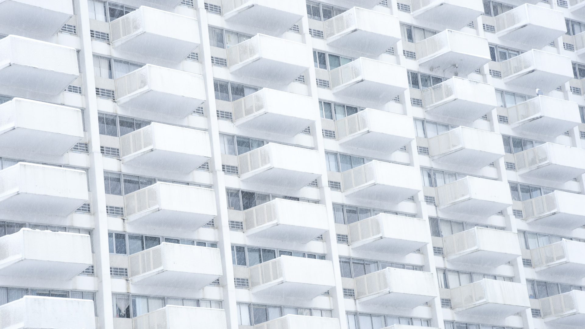 white building facade with repeating geometric balconies